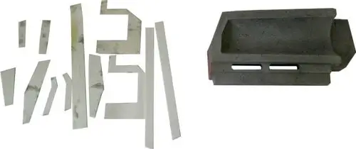 Zwei separate Stücke, eines aus hellen, flachen Materialien und ein grauer, rechteckiger Block mit Aussparung, möglicherweise für die Brennkammer von Wolf-Produkten.